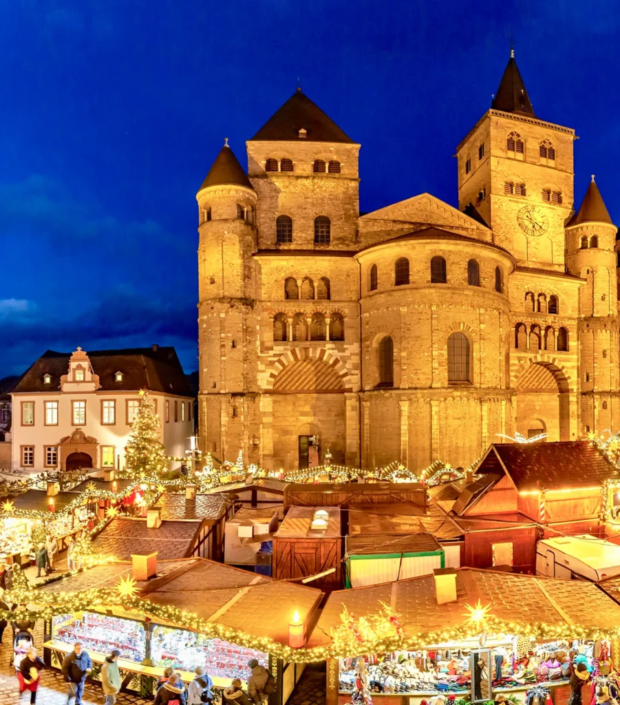 Trierer Dom hinter den beleuchteten Weihnachtsmarktständen