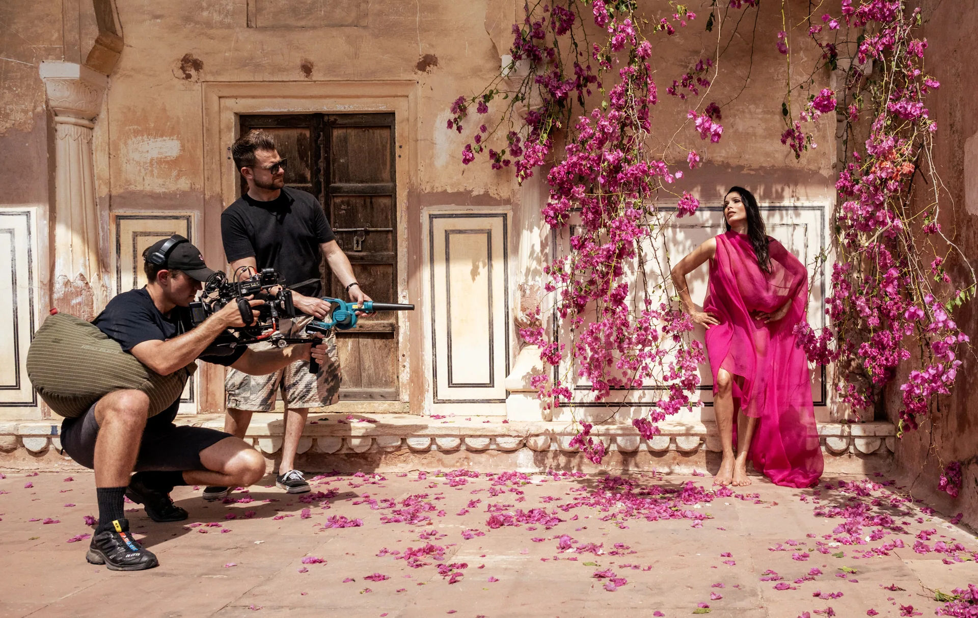 Filmteam beim Shooting mit einem Model in Pink zwischen Blüten